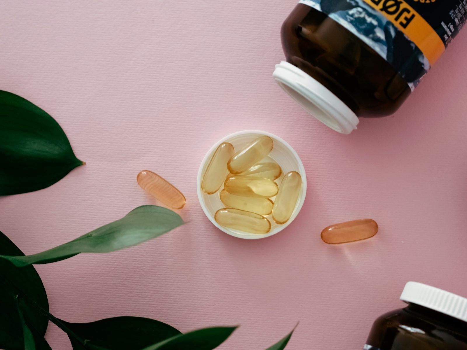 A bowl of oil beside a supplement bottle, illustrating the difference between over-the-counter supplements and research peptides